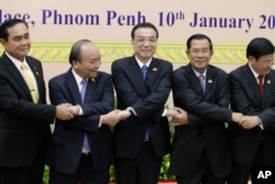 China's Premier Li Keqiang, center, shakes hands with his counterpart, Nguyen Xuan Phuc, second from left, of Vietnam, Prayuth Chan-o-cha, left, prime minister of Thailand, Hun Sen, second from right, of Cambodia, and Thongloun Sisolith, right, of Laos, before an opening of the Lancang-Mekong Cooperation Leaders' Meeting, in Phnom Penh, Cambodia, Jan. 10, 2018.