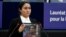 FILE - Jewher Ilham, daughter of Uyghur scholar Ilham Tohti holds a photo of her father during the Sakharov Prize ceremony at the European Parliament, in Strasbourg, France, Dec. 18, 2019. This week marks 10 years since Chinese authorities sentenced Ilham Tohti to life in prison.