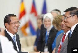 Cambodian Prime Minister Hun Sen, left, smiles as he greets international observers for the July 29 general election, during a welcome meeting at Peace Palace, in Phnom Penh, Cambodia, July 28, 2018. Few of the observers expressed any reservations after the poll.