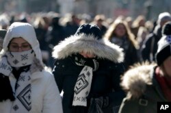 Pedestrians try to keep warm while walking in New York's Times Square, Dec. 27, 2017. Freezing temperatures and below-zero wind chill have descend on much of the northern United States.