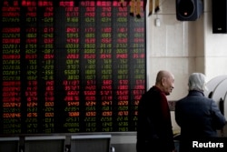 2019年1月18日，在北京一家经纪公司，投资者在显示股票价格的电子板附近聊天。由于北京与华盛顿的关税战谈判可能取得进展，中国股市在这一天上涨。