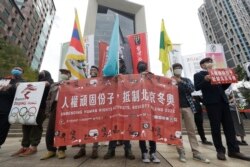 Aksi kelompok hak asasi manusia pada Hari Hak Asasi Manusia internasional PBB, untuk memboikot Olimpiade Musim Dingin Beijing 2022 di depan gedung Bank of China di Taipei, Taiwan, Jumat, 10 Desember 2021.