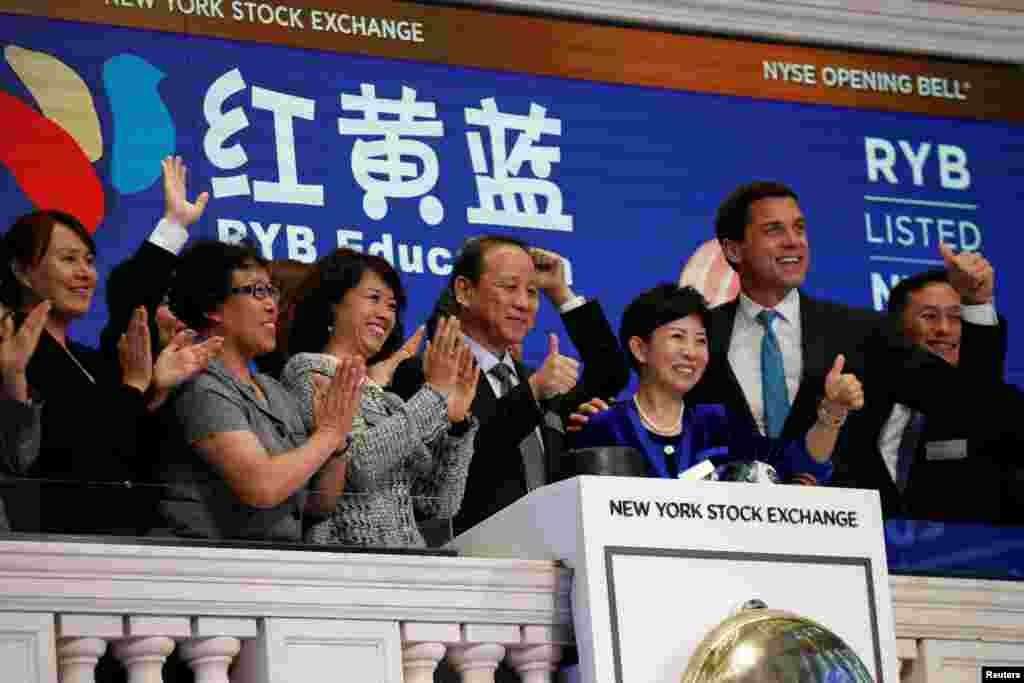 名为“红黄蓝教育”的中国幼教企业在纽约股票交易所上市,创始人和董事长曹赤民(右起第四人)、创始人和总裁史燕来(右起第三人)一起敲钟(2017年9月27日)。该公司在开曼群岛注册,总部位于北京市。