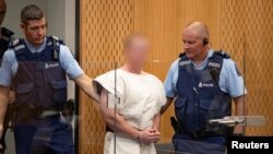 Brenton Tarrant, pelaku penembakan dua masjid di Christchurch, dikawal polisi di pengadilan Distrik Christchurch, Selandia Baru, 16 Maret 2019. (Foto: dok)