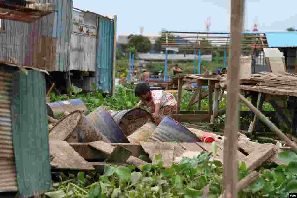 A child moves remnants from a newly demolished floating house in Prek Pra commune, Chbar Ampov district, Phnom Penh, June 12, 2021. (Vicheika Kann/VOA)