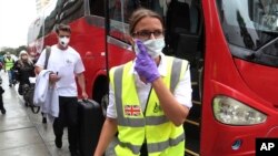 Warga negara Inggris mengikuti pegawai Kedutaan Besar Inggris sebelum diantar menggunakan bus ke bandara di Lima, Peru, untuk diterbangkan ke Inggris, 25 Maret 2020. (Foto: AP)