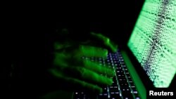 Seorang pria memasukkan kode-kode siber ke dalam komputer, 1 Maret 2017. (Foto: Reuters)