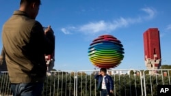 2014年11月6日，一名男孩在APEC北京峰会标志附近拍照。为了能让与会者呼吸到更清新的空气，中国政府采取了一系列强制措施。