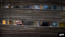 一名戴着口罩的男子在武汉的一个街道上穿过一个障碍物。(2020年4月3日)