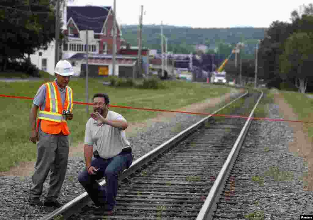 Insurance inspectors walk the rail line heading toward the center of the town in Lac Megantic, Quebec, Canada, July 10, 2013.