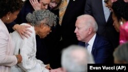 美国总统拜登在白宫东厅正式签署法律将六月节设为联邦假日后，与奥帕尔·李握手交谈。（2021年6月17日）