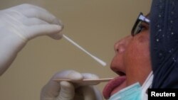 Seorang pekerja sedang melakukan tes usap Covid-19 terhadap seorang perempuan. (Foto: ilustrasi)