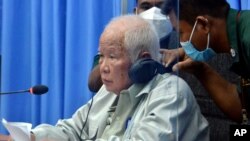 FLIE - Khieu Samphan, left, the former head of state for the Khmer Rouge, sits in a courtroom during a hearing at the U.N.-backed war crimes tribunal in Phnom Penh, Cambodia, Aug. 19, 2021.