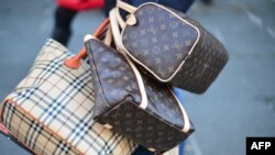 Seorang penjual menjajakan tas-tas palsu di sebuah jalan di Roma, Italia (foto: ilustrasi). 
