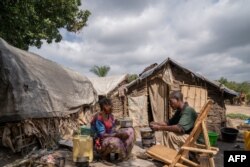 FILE - People displaced by conflict sit in a camp in Komanda, Ituri province, eastern Democratic Republic of Congo, Aug. 30, 2023.