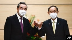 日本首相菅义伟在东京会晤到访的中国外长王毅。（2020年11月25日）