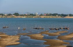 FILE - Fishing boats are moored in Mekong River, which has turned blue instead of its usual muddy color, in Nakhon Phanom province, northeastern Thailand, Dec. 4, 2019.