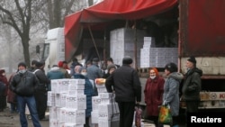 FILE - Residents gather near a trailer full of food and hygiene products from the International Committee of the Red Cross in the rebel-controlled city of Donetsk, Ukraine, March 17, 2021. U.N. agencies have made two such deliveries in April. 
