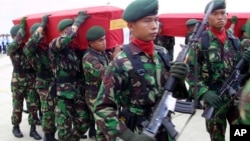 Beberapa anggota TNI mengusung peti jenazah rekan-rekan mereka yang tewas dalam bentrokan dengan kelompok separatis di Provinsi Papua, pada saat di Bandara Juanda, Surabaya, 11 April 2006.