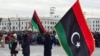Des Libyens brandissent le drapeau national sur la place des Martyrs à Tripoli, le 17 février 2025, lors d'un rassemblement pour commémorer le 14e anniversaire du soulèvement qui a renversé Mouammar Kadhafi, l'homme fort de longue date. (Photo par AFP)