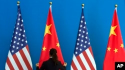 一名中国女子在整理美国和中国国旗（资料照片）