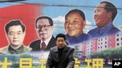 有人骑自行车路过山西的一块带有邓小平等领导人画像的公告牌（2009年2月）