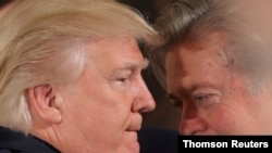 FILE PHOTO: U.S. President Donald Trump talks to chief strategist Steve Bannon during a swearing in ceremony for senior staff at the White House in Washington