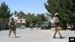 FILE - Afghanistan, security forces take position during a fighting outside a government compound in the city of Lashkar Gah, capital of Helmand province, Afghanistan, May. 13, 2015. 