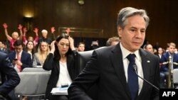 Državni sekretar SAD Entoni Blinken na pretresu u Senatu o pomoći Ukrajini i Izraelu, dok se iza njega nalaze antiratni demonstranti, 31.oktobar 2023.