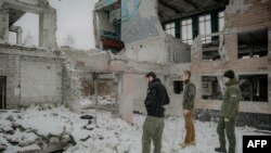 Des soldats ukrainiens visitent le site des bombardements russes où leurs camarades sont morts, lors d'un événement dédié à la mémoire des soldats ukrainiens tombés, à Kharkiv le 2 mars 2025.