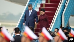 Presiden China Xi Jinping, kiri, dan istrinya Peng Liyuan, kanan, tiba di Bandara Internasional Noi Bai di Hanoi, Vietnam, Selasa, 12 Desember 2023. (Foto: via AP)