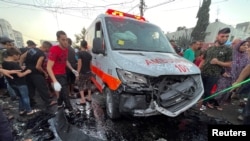 Warga Palestina memeriksa kerusakan setelah konvoi ambulans dihantam, di pintu masuk Rumah Sakit Shifa di Kota Gaza, 3 November 2023. (Foto: REUTERS/Mohammed Al-Masri)