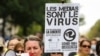 A woman wearing a yellow vest and speaking in a loud hailer, holds a placard reading "Media are the virus ..." during a demonstration against the mandatory COVID-19 health pass in Paris on Sept. 4, 2021