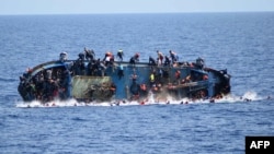 This handout picture released on May 25, 2016 by the Italian Navy (Marina Militare) shows the shipwreck of an overcrowded boat of migrants off the Libyan coast today. 