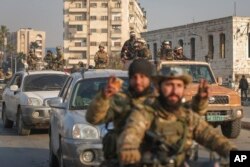 Syrian opposition fighters ride along the streets in the aftermath of the opposition's takeover of Hama, Syria, Dec. 6, 2024.