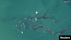 FILE - A satellite image shows flooded homes near the Uzbekistan-Kazakhstan border following the collapse of the Sardoba dam in Uzbekistan, May 3, 2020. 