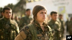 叙利亚民主军的战士们23日在庆祝击败伊斯兰国的仪式上列队.