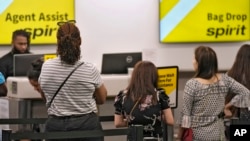 FILE - Passengers wait in a line for help at the Spirit Airlines ticket counter at the Tampa International Airport, June 1, 2023, in Tampa, Fla.