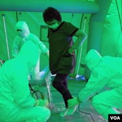 Star medis memindai seorang perempuan untuk mendeteksi kemungkinan radiasi di tubuhnya, setelah ia dievakuasi dari sebuah daerah berjarak 20 kilometer dari PLTN, Rabu (16/3).