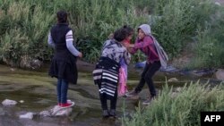 Para imigran menyeberangi Rio Grande antara Ciudad Juarez, Meksiko dan El Paso, Texas, 29 April 2019.
