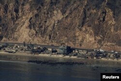 An aerial view shows debris from burned properties, as powerful winds fueling devastating wildfires in the Los Angeles area force people to evacuate, in Malibu, California, Jan. 10, 2025