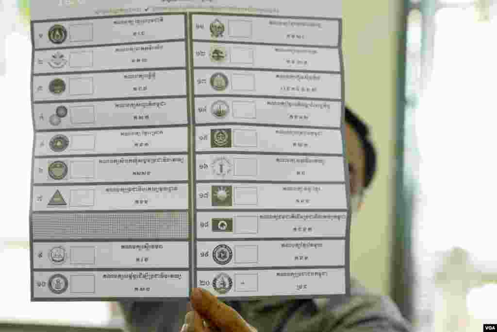 មន្ត្រីរៀបចំការបោះឆ្នោតលើកបង្ហាញសន្លឹកឆ្នោតមួយសន្លឹក​​ បន្ទាប់ពីការិយាល័យ​បោះឆ្នោតនៅទូទាំងប្រទេសបានបិទ នៅសង្កាត់បឹងកេង​កង២ ខណ្ឌ​ចំការមន រាជធានីភ្នំពេញ​ នៅ​ថ្ងៃអាទិត្យ​ ទី២៩ ខែកក្កដា​ ឆ្នាំ២០១៨។ (ខាន់ សុគុំមនោ/VOA)