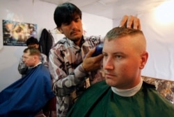Warga Afghanistan memotong rambut tentara AS dari Batalyon ke-2, Divisi Infanteri ke-35, Satuan Tugas Kaktus di sebuah pangkas rambut di Provinsi Kunar, Afghanistan timur 13 Maret 2012. (Foto: REUTERS/Erik De Castro)