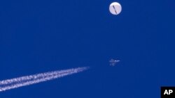 2023年2月4日一个气球漂浮在南卡罗来纳州海岸附近大西洋上空，下面是一架战斗机的飞行轨迹。