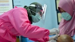 Seorang petugas medis memberikan vaksinasi kepada seorang bayi yang digendong ibunya di Banda Aceh. (ilustrasi) Pernyataan Mahfud MD dinilai merendahkan martabat perempuan dalam hubungan rumah tangga.