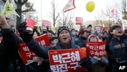 Para pemrotes membawa spanduk bertuliskan "Tahan Park Geun-hye" sambil meneriakkan slogan saat berpawai menuju kantor Presiden di Seoul, 10 Desember 2016 (AP Photo/Ahn Young-joon).