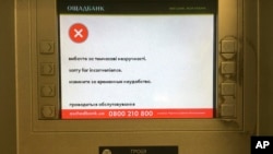 一部乌克兰国有银行的提款机频幕上显示出遭到攻击正在修复的字样。