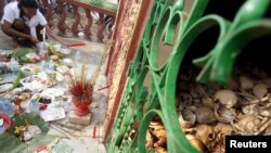 A woman pays her respects to relatives who died during the Khmer Rouge regime at a memorial for the victims, in Kampot province, April 15, 2015.