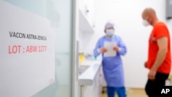 ស្លាកសញ្ញា​នៅ​លើ​ទ្វារ​បង្ហាញ​ពី​ការចាក់​វ៉ាក់សាំង AstraZeneca ដែល​ត្រូវបាន​ប្រើ​នា​ពេល​បច្ចុប្បន្ន​នេះ នៅ​ឯ​មជ្ឈមណ្ឌល​ចាក់​វ៉ាក់សាំង​ក្នុង​ទីក្រុង Bucharest ប្រទេស​រ៉ូម៉ានី នៅ​ថ្ងៃពុធ ទី៧ ខែមេសា ឆ្នាំ២០២១។