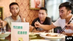 中国河北邯郸市一家餐馆桌子上立有“节约粮食杜绝浪费”的牌子。（2020年8月13日）